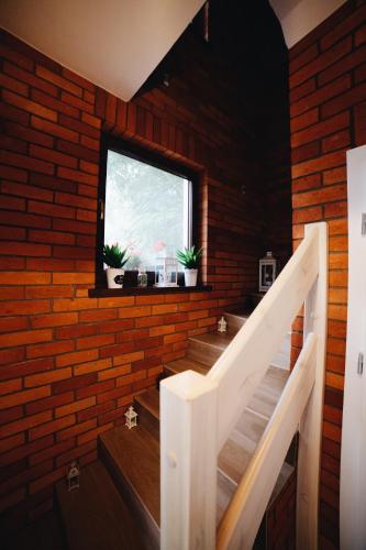 a brick walled room with stairs and a window at Gościniec Kaszubski Las, Ruda 3 in Bartoszylas
