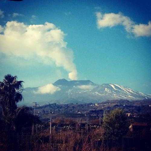 a snow capped mountain in the distance with a city at Case Vacanze Blue Sea in Mascali