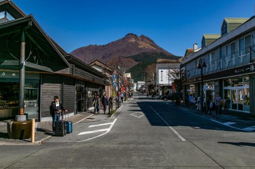 a street in a town with a mountain in the background at Yufuin Lamp no Yado in Yufuin