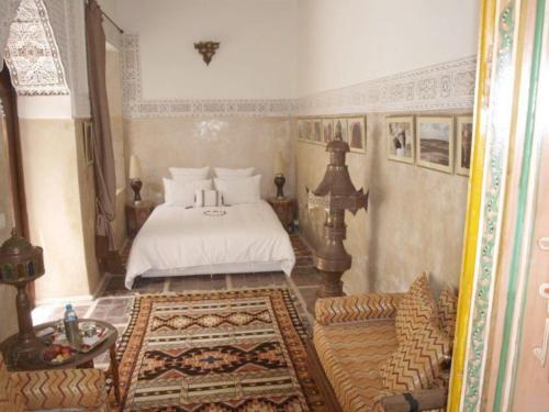 a bedroom with a bed and a couch in it at Riad Al Loune in Marrakech