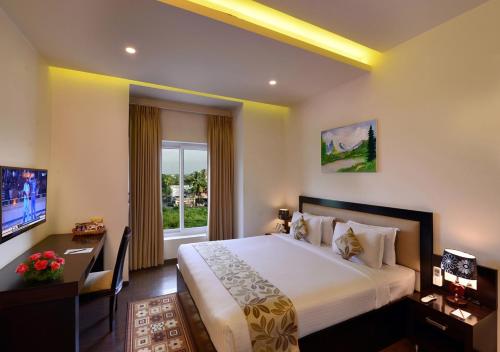 a hotel room with a large bed and a window at Royal Ritis in Shimoga