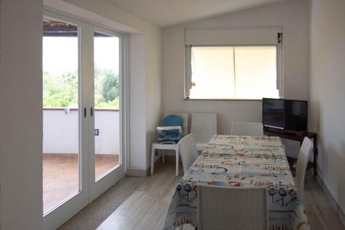 a dining room with a table and a sliding glass door at Casa Relax in Siniscola