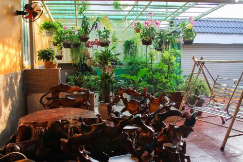 a patio with a table and some potted plants at Nature House Homestay in Ho Chi Minh City