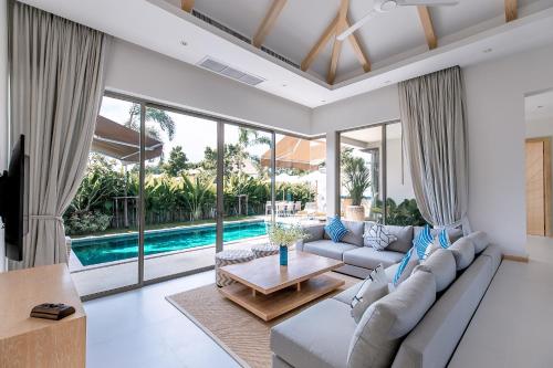 una sala de estar con un sofá y una mesa en Modern 3BR Villa with Private Pool and BBQ, en Bang Tao Beach