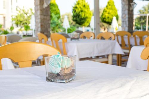 a glass jar filled with sand and seashells on a table at Evita in Faliraki