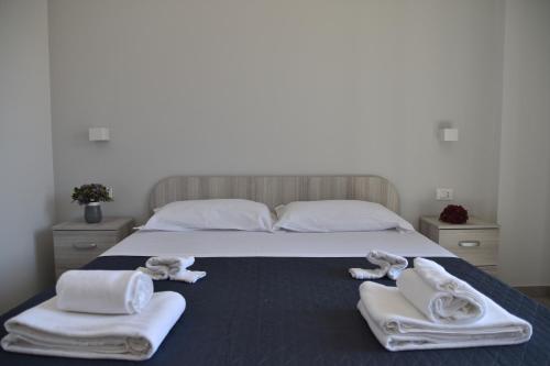 a bedroom with a bed with towels on it at Case Vacanze Blue Sea in Mascali