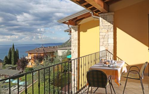 a table on a balcony with a view of the ocean at Residence Besass, GTSGroup in Tignale