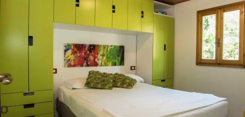 プントーネ・ディ・スカルリーノにあるCamping Piperの緑と白のキャビネット、ベッド1台が備わるベッドルーム1室が備わります。