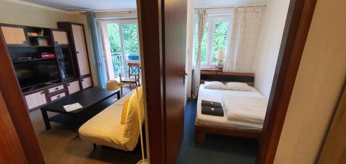 een kleine kamer met 2 bedden en een televisie bij Apartament RSL in Ruda Śląska