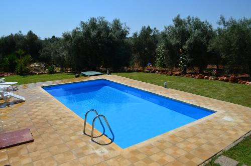 a large blue swimming pool in a yard at VILLA L&M in Floridia