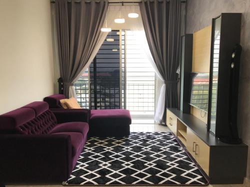 uma sala de estar com sofás roxos e uma televisão de ecrã plano em Wan Homestay Putra Impian em Kajang