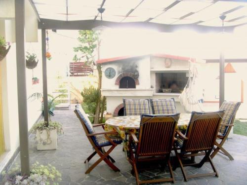 patio ze stołem, krzesłami i kominkiem w obiekcie Le Vallonee B&B w mieście Aradeo
