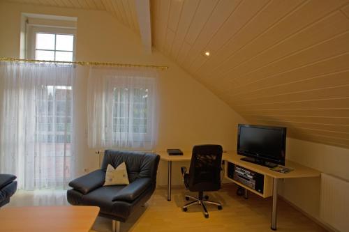 a living room with a desk with a tv and chairs at Engelhard Das Landhotel Garni in Kirchheim am Ries