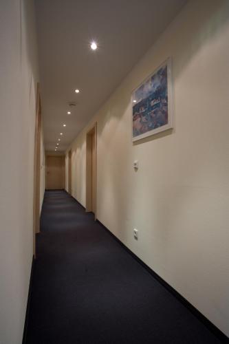 a hallway of an office building with a painting on the wall at Engelhard Das Landhotel Garni in Kirchheim am Ries
