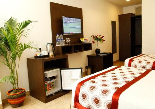a bedroom with a bed and a tv in a room at M B Greens Clarks Inn in Morādābād