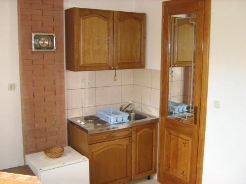 a small kitchen with wooden cabinets and a sink at Villa Maria in Lastovo