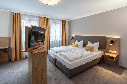 a bedroom with a bed and a flat screen tv at Hotel & Restaurant Ritter Jörg in Sommerhausen