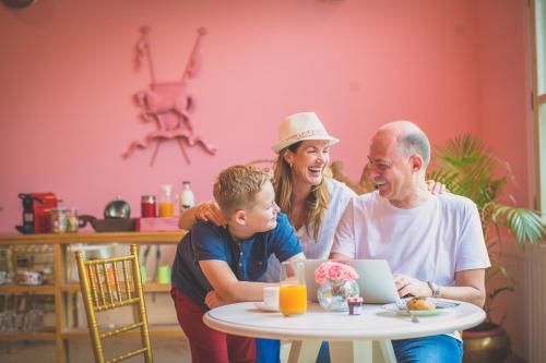 a family sitting at a table with a laptop at Rose Amer in Jaipur