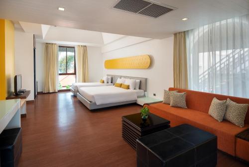 a living room with a couch and a bed at Z Through By The Zign in North Pattaya
