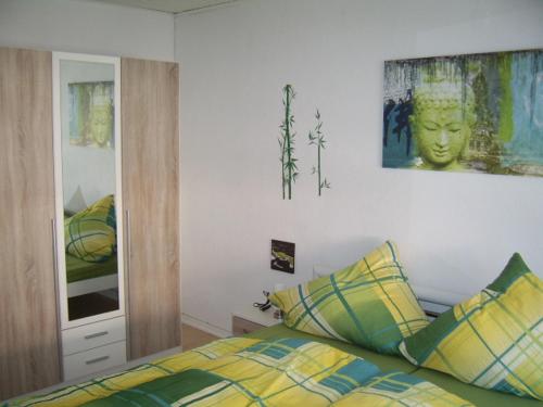 a bedroom with a bed with yellow and green pillows at Ferienhaus Mosel/Trittenheim in Trittenheim