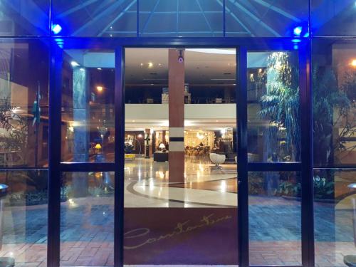 an entrance to a building with glass doors at Constantino Hotel e Eventos in Juiz de Fora