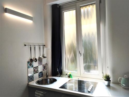 uma cozinha com um lavatório e uma janela em Beautiful Open-Space Loft em Milão