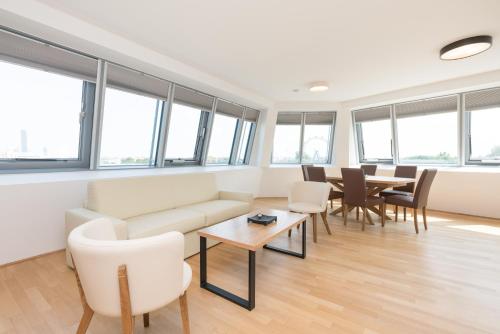 ein Wohnzimmer mit einem Sofa, Stühlen und Tischen in der Unterkunft Yourapartment Prater in Wien