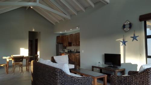 a living room with chairs and a table and a tv at Sunset Lagoon in Port Nolloth