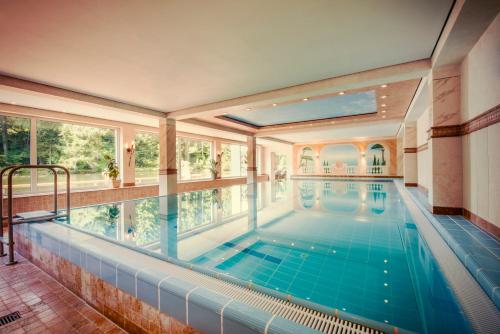 an indoor pool in a house with a large window at Hotel Langenwaldsee in Freudenstadt