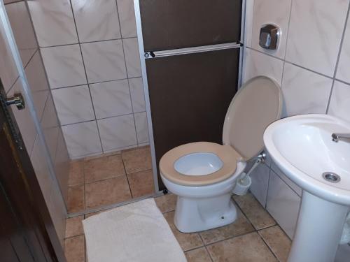 a small bathroom with a toilet and a sink at Schulz Pousada in Joinville
