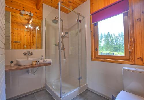 a bathroom with a shower and a sink at Bieszczady Resort in Polańczyk