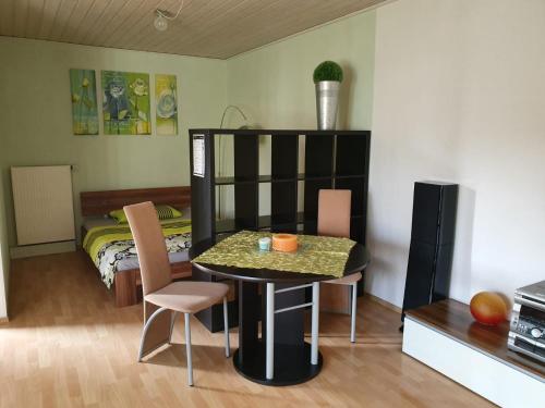 CaldenApartment/Ferienwohnung im ruhigen Calden in der nähe von Kassel的一间有桌子、椅子和床的房间