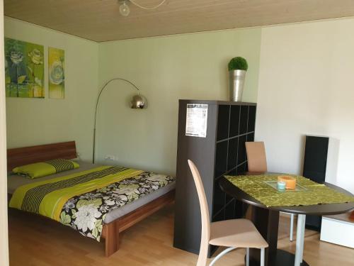 1 dormitorio con 1 cama y 1 mesa con comedor en Apartment/Ferienwohnung im ruhigen Calden in der nähe von Kassel, en Calden