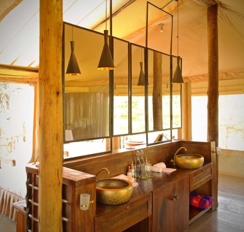 a bathroom with two sinks in a room with windows at Saruni Leopard Hill in Naboisho