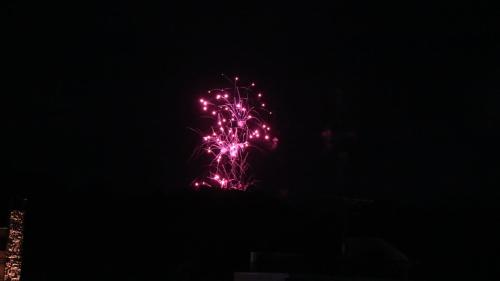 a firework display in the sky at night at Benidaruma - Dango in Kyoto