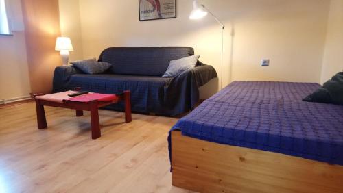 ein Wohnzimmer mit einem Sofa, einem Bett und einem Tisch in der Unterkunft Fewo Altengroden Süd in Wilhelmshaven