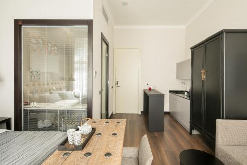 a living room with a table and a kitchen at Quentin Prague Hotel in Prague
