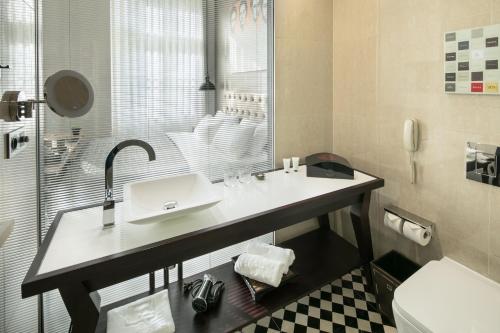 a bathroom with a sink and a toilet at Quentin Prague Hotel in Prague