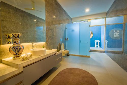 een badkamer met een wastafel, een toilet en een spiegel bij Rose Amer in Jaipur