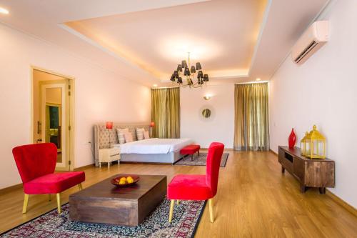 a bedroom with a bed and red chairs in a room at Rose Amer in Jaipur