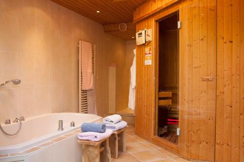 uma casa de banho com uma banheira e um lavatório em De Kersenbongerd em Ingen