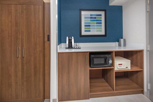 a room with a counter with a microwave and a kitchen at Holiday Inn Express Hotel & Suites San Diego Airport - Old Town, an IHG Hotel in San Diego