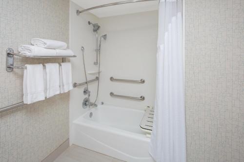 a bathroom with a tub and a shower with towels at Holiday Inn Express Hotel & Suites San Diego Airport - Old Town, an IHG Hotel in San Diego