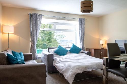 Schlafzimmer mit einem Bett und einem Fenster mit blauen Kissen in der Unterkunft Carvetii - Borthwick House - Ground floor flat in Kinghorn