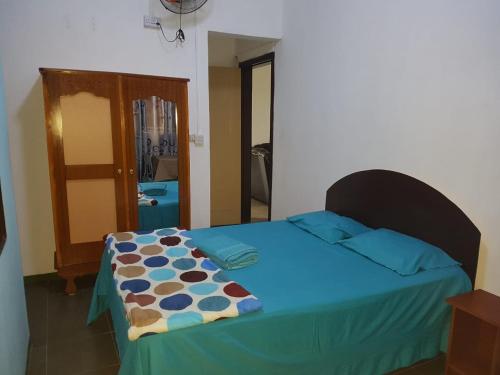 a bedroom with a bed with a blue blanket on it at Villa Pte Aux Piments in Pamplemousses Village