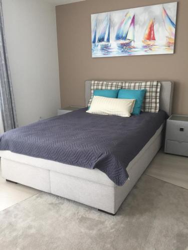 ein Schlafzimmer mit einem großen Bett mit blauen und weißen Kissen in der Unterkunft Ferienwohnung Lörrach Alice in Lörrach