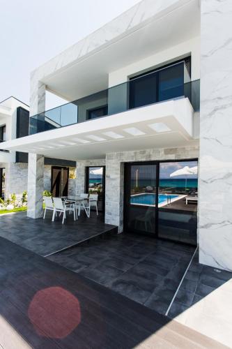a modern house with a patio with a view of the ocean at Crystal villas & suites in Polykhrono
