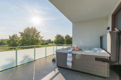 a balcony with a bath tub on a balcony at Luxus_SPA_OG_Fewo QUARTIER 4 _WE 4_ in Göhren-Lebbin