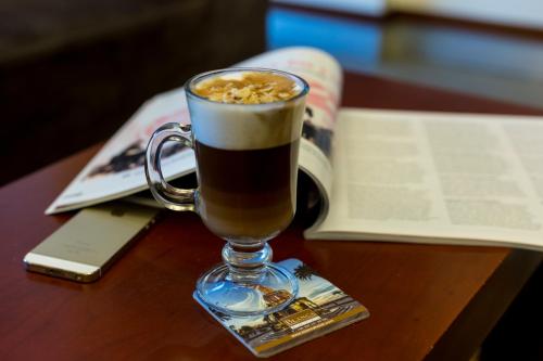 a cup of coffee on a table with a book at Blanca Hotel in Izmir