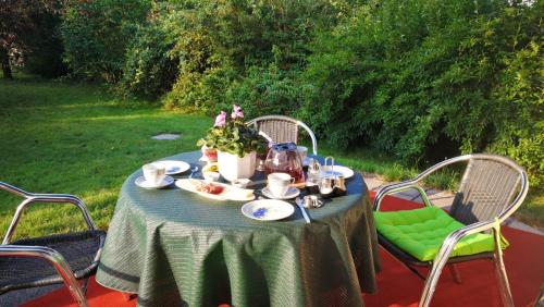 uma mesa com um bule de chá e flores sobre ele em Ferienwohnung am Spreeradweg em Neusalza-Spremberg